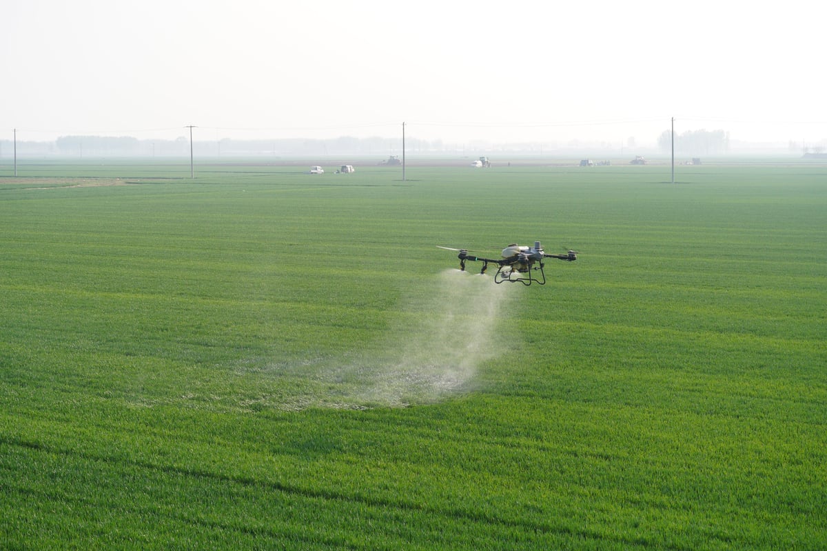 Agricultural drone flying over farmland for crop spraying and precision agriculture
